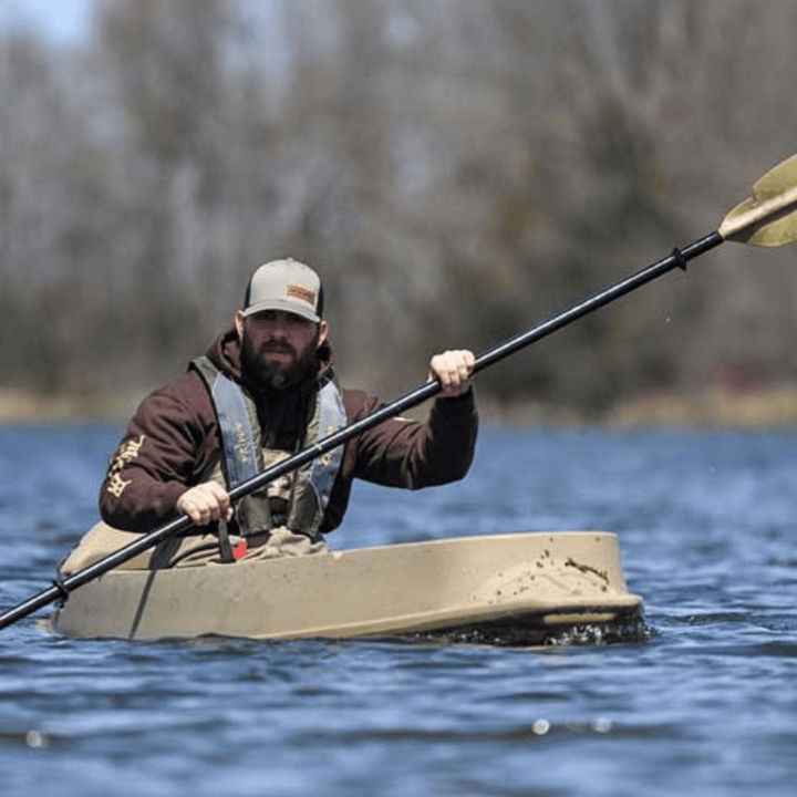 Brown Beavertail Phantom Sneakboat sit-inside paddle kayak by Meyer, 10 ft 7 in, shown on calm water with paddle inside.