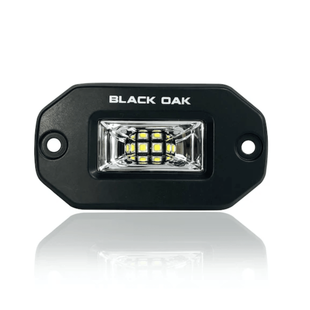 Black Oak 2-inch black marine LED flush mount spreader light with black housing, suitable for boat and marine lighting.