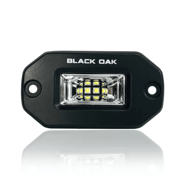 Black Oak 2-inch black marine LED flush mount spreader light with black housing, suitable for boat and marine lighting.