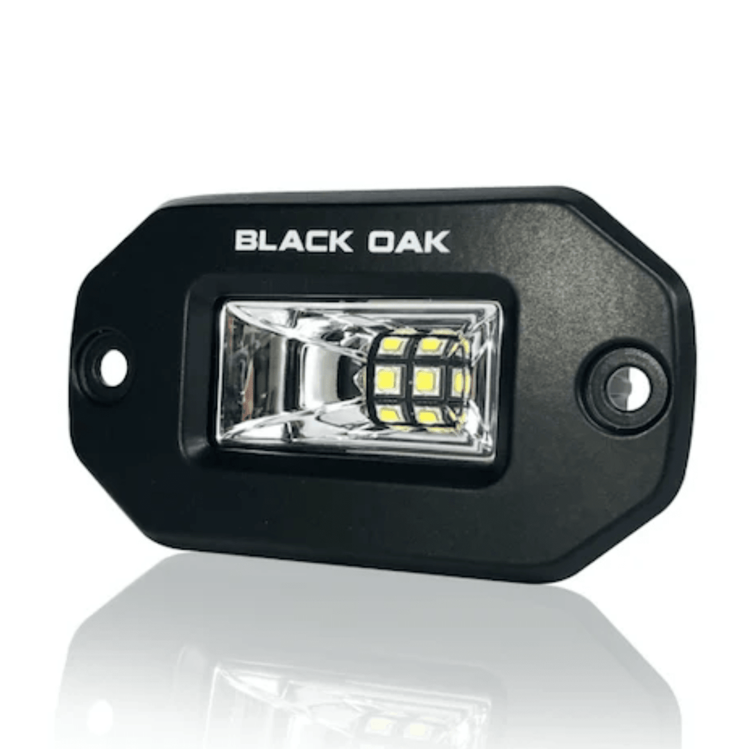 Black Oak LED 2-inch black marine flush mount spreader light with black housing, ideal for boat lighting applications.