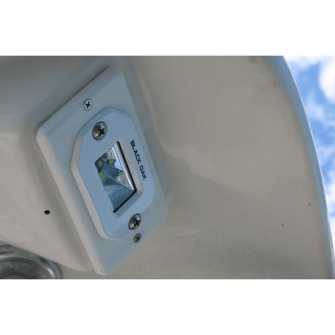 Black Oak 2-inch marine LED flush mount spreader light with white housing, ideal for boat lighting and marine applications.
