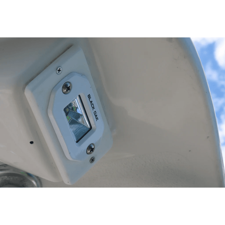 Black Oak 2-inch marine LED flush mount spreader light with white housing, ideal for boat lighting and marine applications.