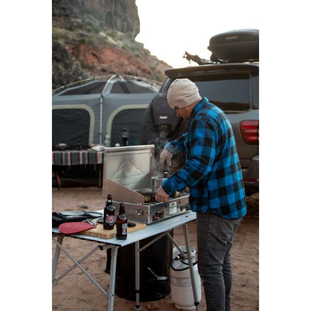 Chattanooga Camp Chef Mountaineer aluminum two-burner portable outdoor cooking system with sturdy metal surface and control knobs.