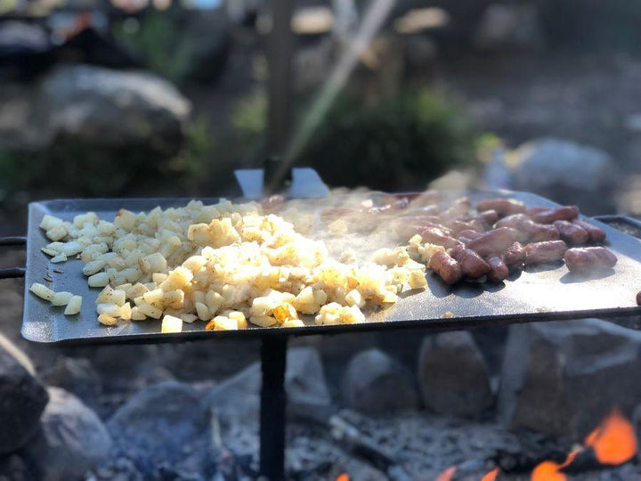 Chattanooga Camp Chef Mountain Man Grill portable outdoor cooking griddle made of durable steel for camping and outdoor grilling.