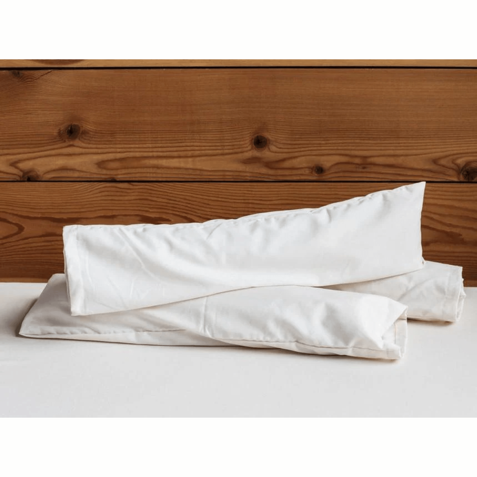 Holy Lamb Organics neck roll support cushion for sleep and relaxation, soft fabric with a cylindrical shape and plush filling.