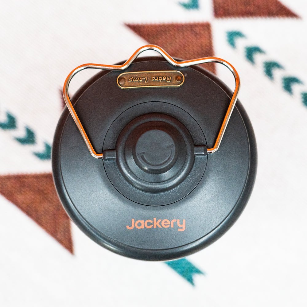 Jackery camping lantern emitting bright light, portable outdoor camping light with handle for camping and hiking trips.