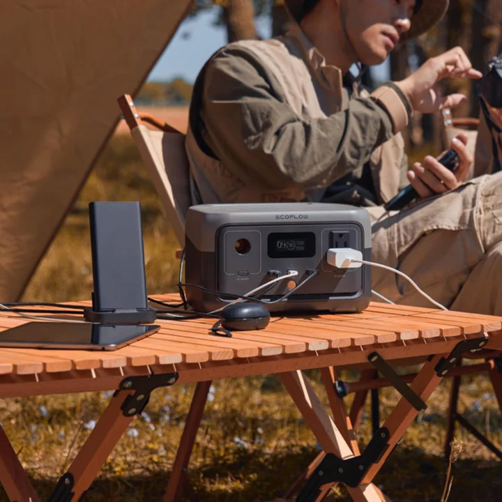 EcoFlow RIVER 2 Portable Power Station Lightweight Reliable Fast Charging Energy in a camping setup with devices charging.